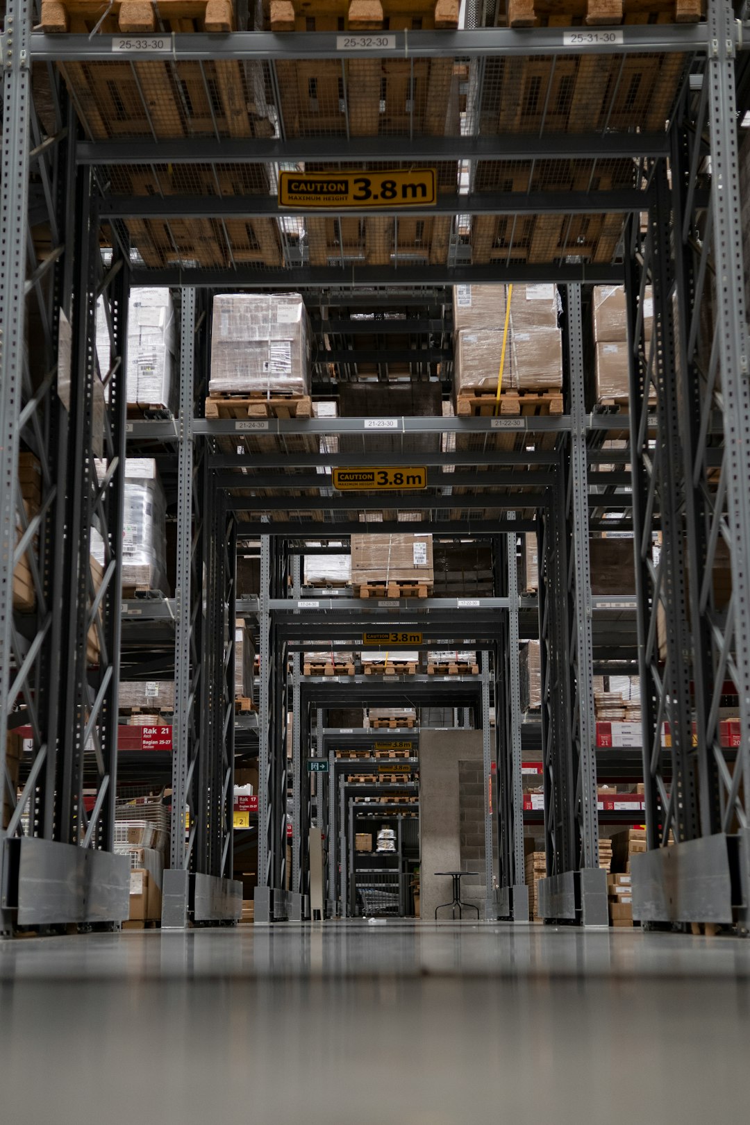 Modern warehouse interior with tall storage racking and 3.8m clearance signage